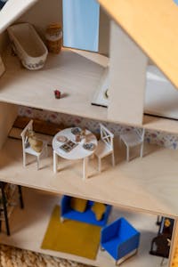 Detailed view of a dollhouse interior showing a dining room and bathroom setup.
